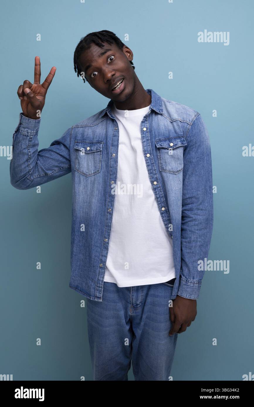 Bell'uomo africano con capelli ricci in giacca denim Foto Stock
