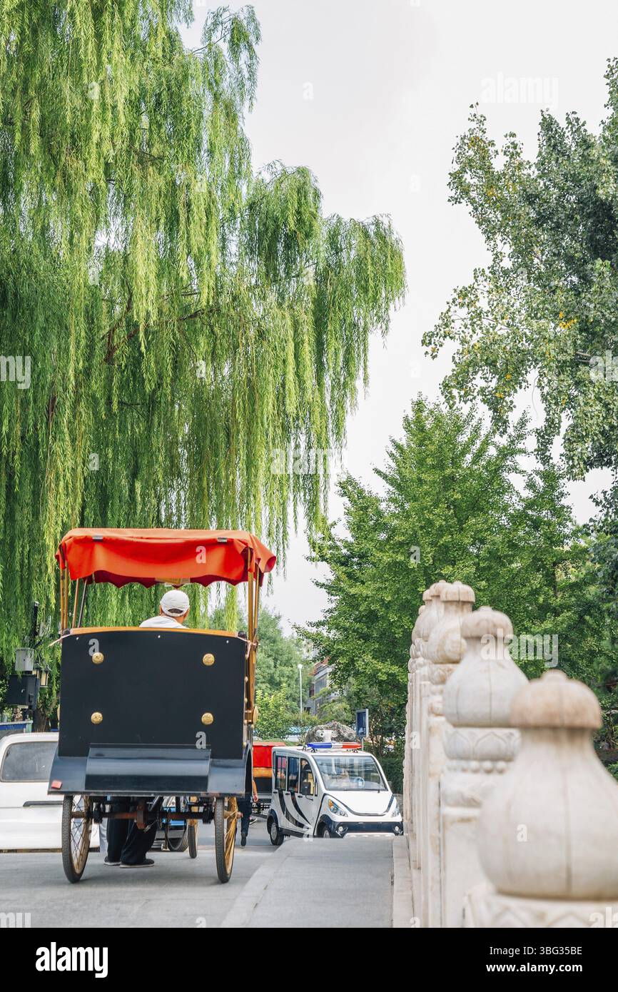 Vecchio risciò tradizionale cinese sul ponte Jinding sul lago Shichahai Qianhai a Pechino, Cina, Asia Foto Stock