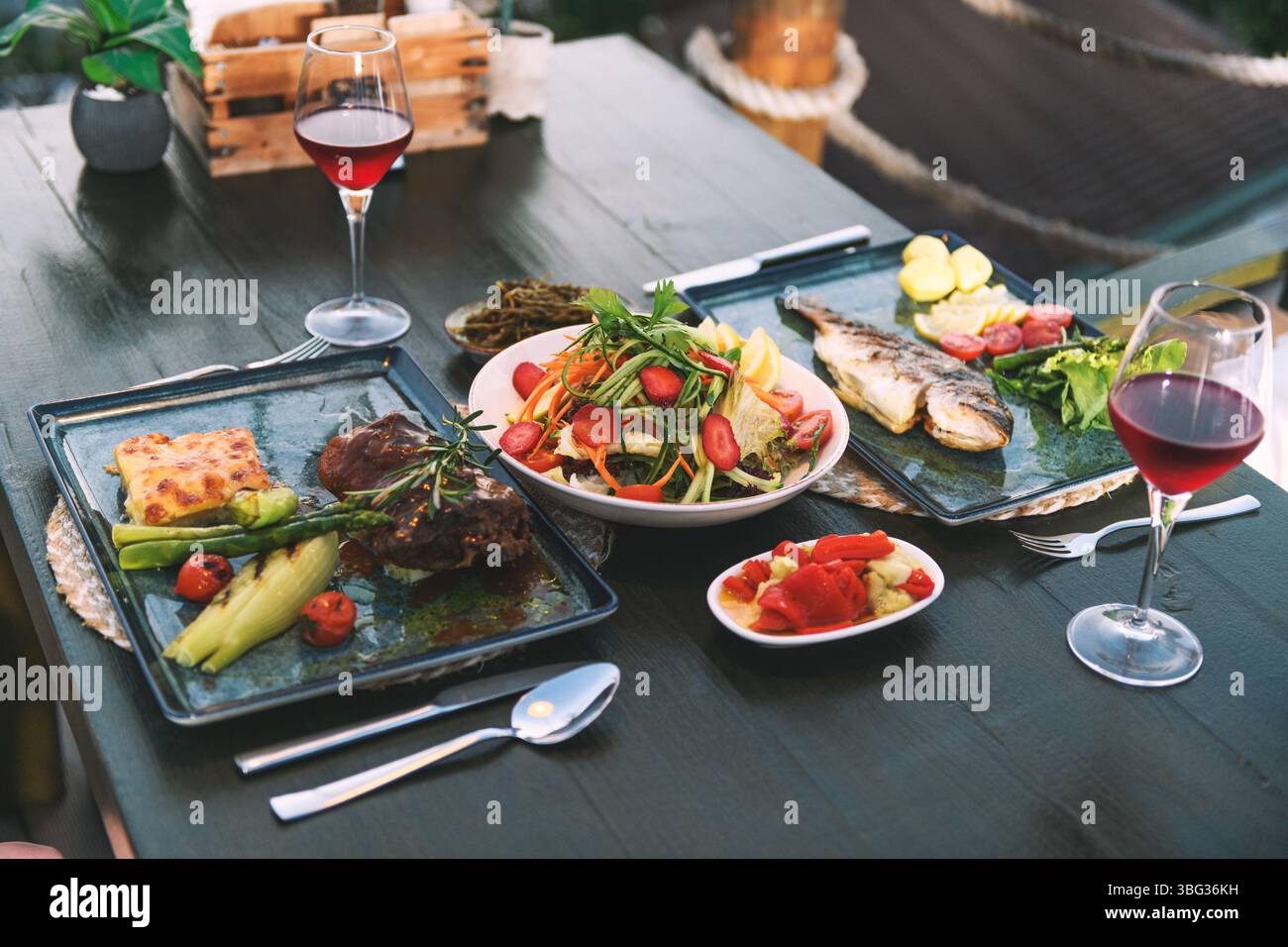 Un piatto di carne e pesce presentato in modo splendido servito in un elegante ristorante dell'hotel, che mette in mostra l'eccellenza culinaria. Foto Stock