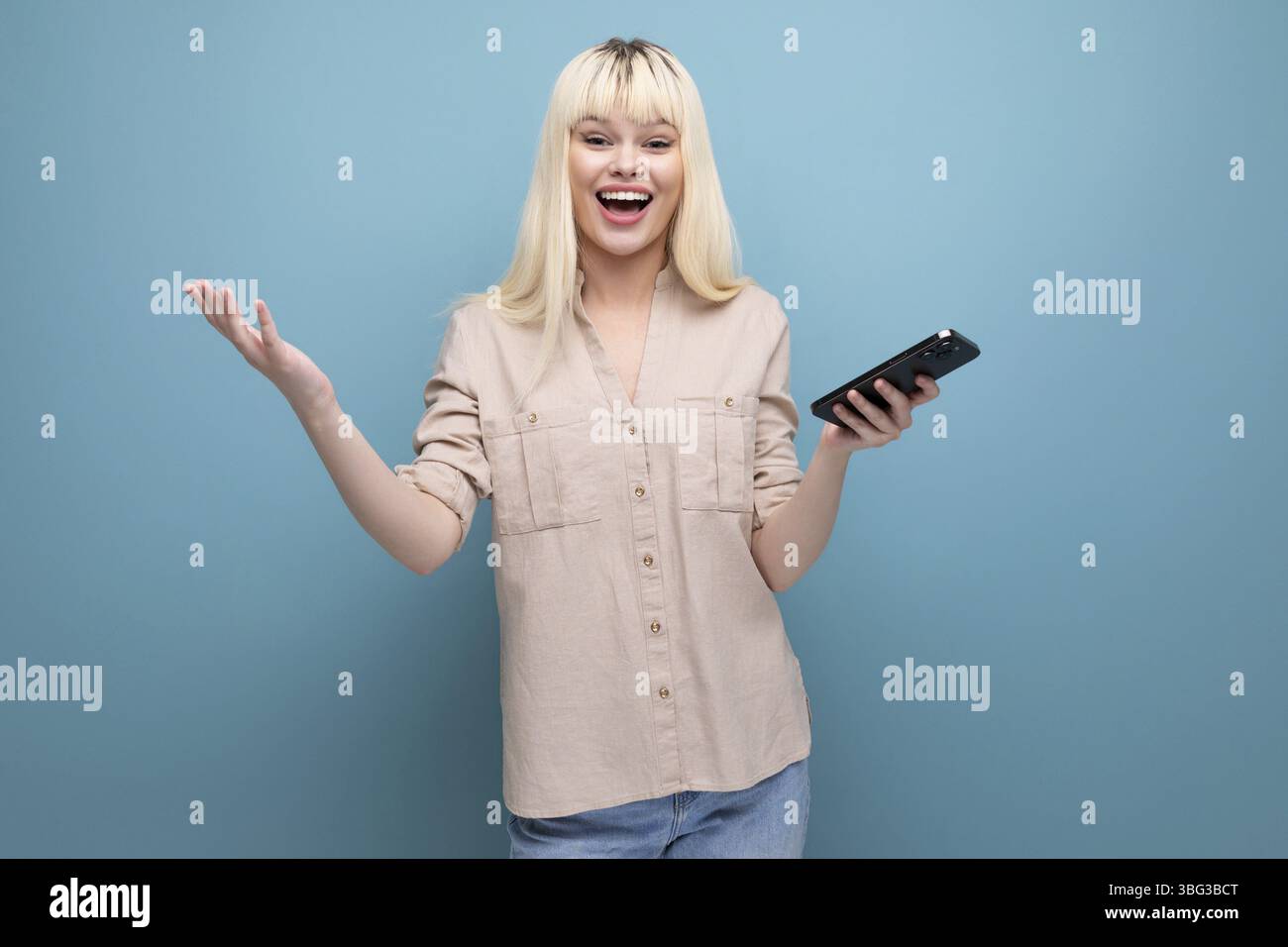 Ritratto di una giovane donna europea abbastanza bionda che guarda lo schermo dello smartphone Foto Stock