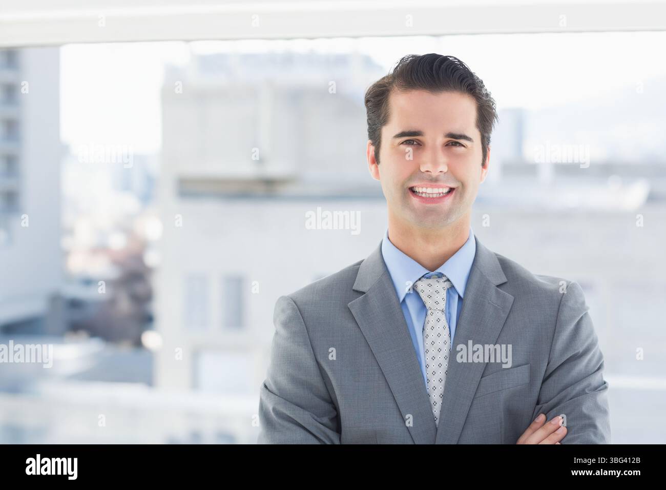 Braccio professionale maschile, con tuta grigia e cravatta a fantasia, grande finestra, spazio per copiare Foto Stock