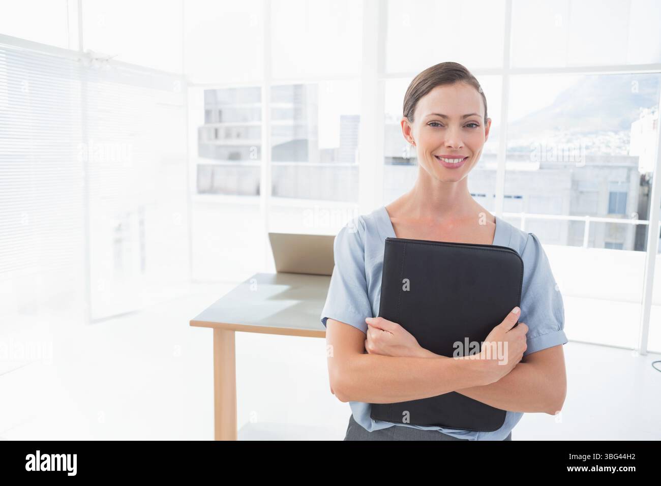 Donna bianca adulta che indossa un casual aziendale in ufficio con legante nero accanto al computer portatile e spazio per le copie Foto Stock