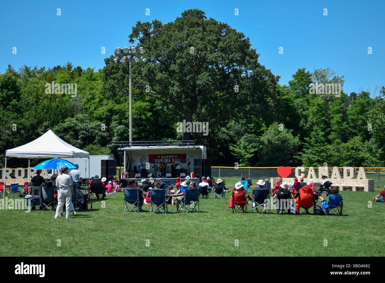 July1, 2024 - Aurora, Ontario, Canada: Persone sedute su sedie che guardano band dal vivo sul palco, celebrando il Canada Day al Lambert Willson Park Foto Stock