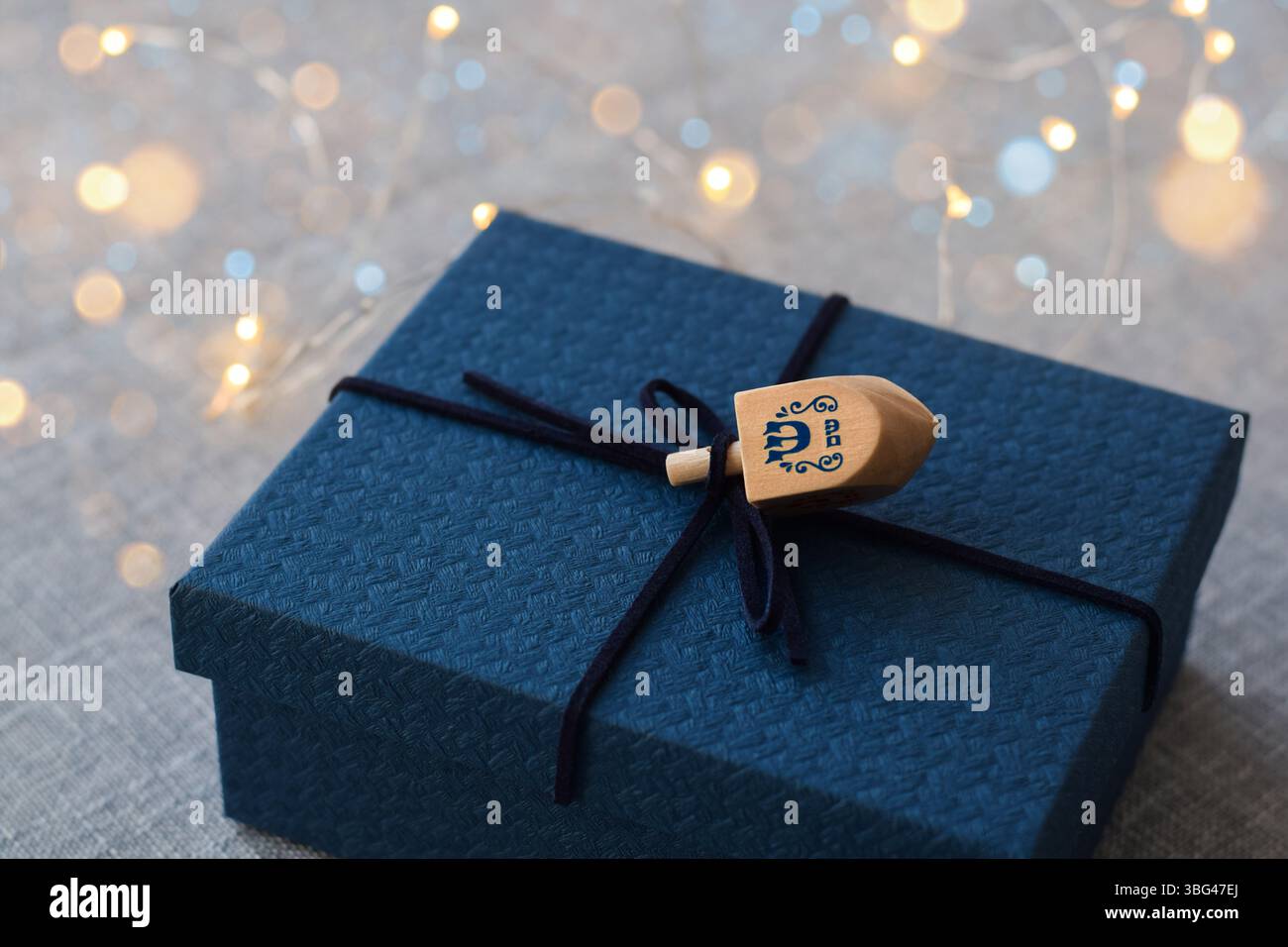 Scatola blu Channuka presente con luci dreidel e bokeh Foto Stock