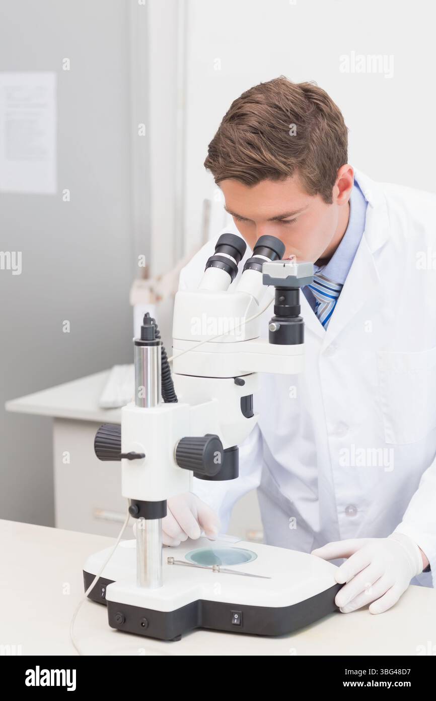 Microscopio binoculare per scienziati su banco da laboratorio con capsula di Petri, sonda e tastiera Foto Stock