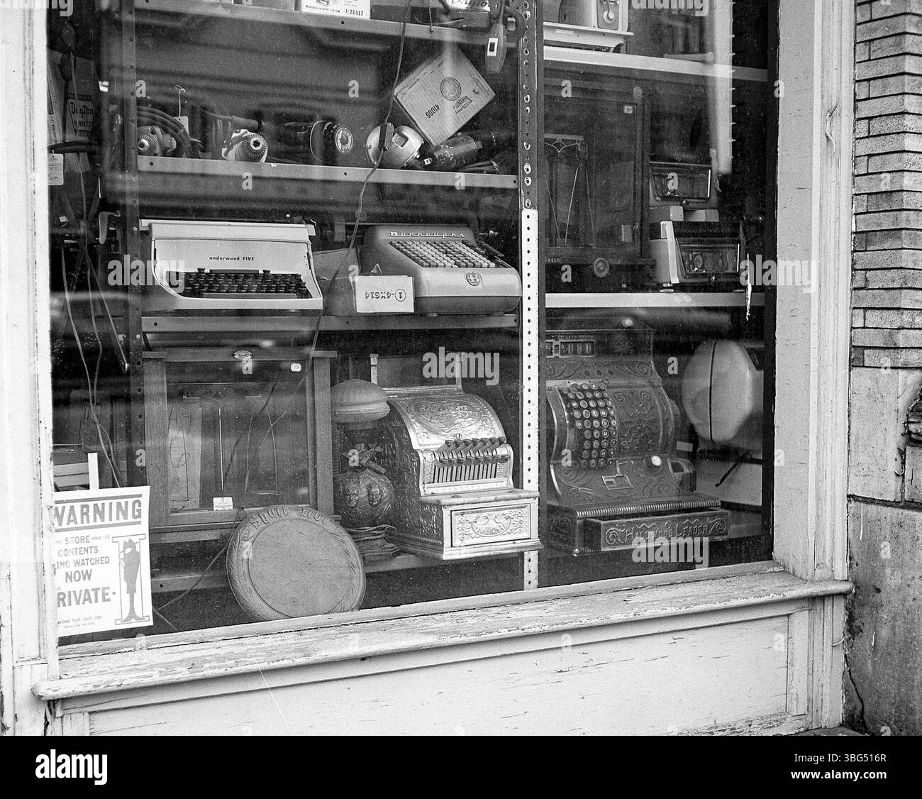 Questa foto del 1976 mostra un'esposizione di merci presso la General Merchandise Liquidating Company. Sono presenti un registratore di cassa Hallwood leader, un modello della National Cash Register Company, una macchina da scrivere Underwood Five e una macchina per l'aggiunta Burroughs, che mette in mostra attrezzature per ufficio e vendita al dettaglio dell'epoca. Foto Stock