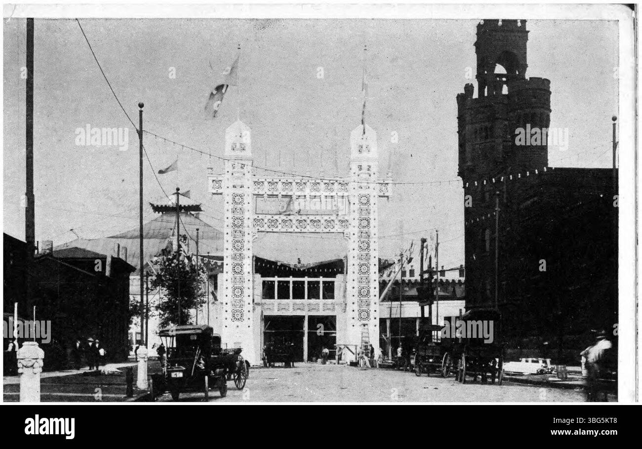 Una vista del 1910 di un edificio espositivo a Cleveland, caratterizzato da un intricato ingresso in un'arena tendata, carri trainati da cavalli, prime automobili e un edificio decorato simile a un castello, possibilmente una caserma dei pompieri o un'armeria. Foto Stock