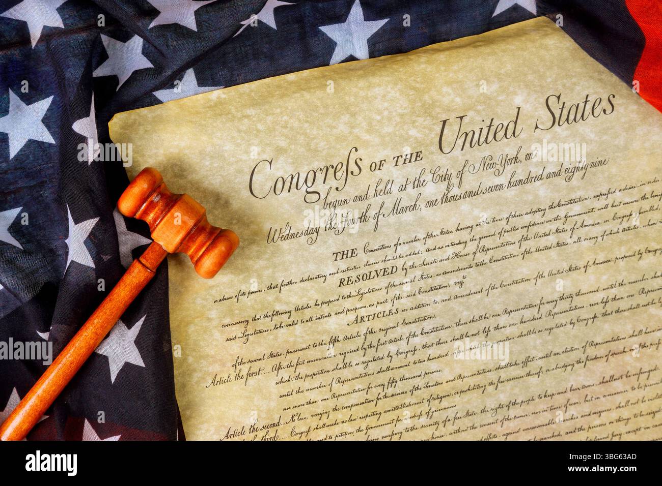 Importanti risoluzioni del Congresso sono presentate sulla pergamena accanto al martelletto Justice, tessuto di bandiera americana. Foto Stock