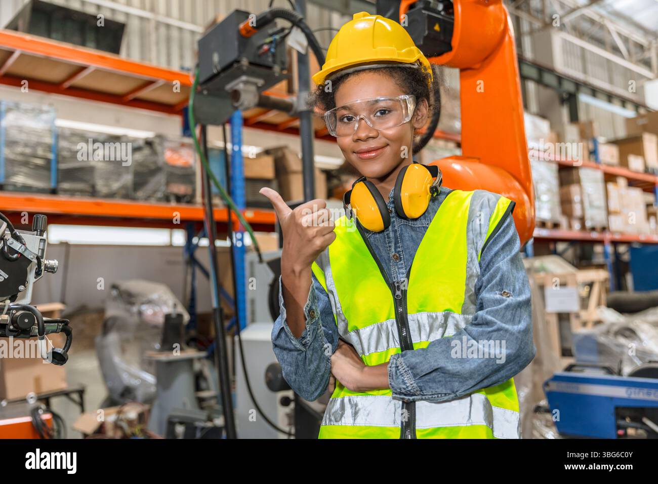 giovane ingegnere professionista, tecnico che lavora in una moderna fabbrica industriale robot braccio di saldatura operatore di controllo della macchina Foto Stock