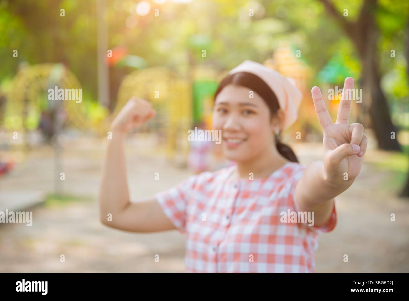 Bella giovane donna asiatica sana e grassa in piedi felice sorridente al parco verde di ricreazione sportiva all'aperto Foto Stock