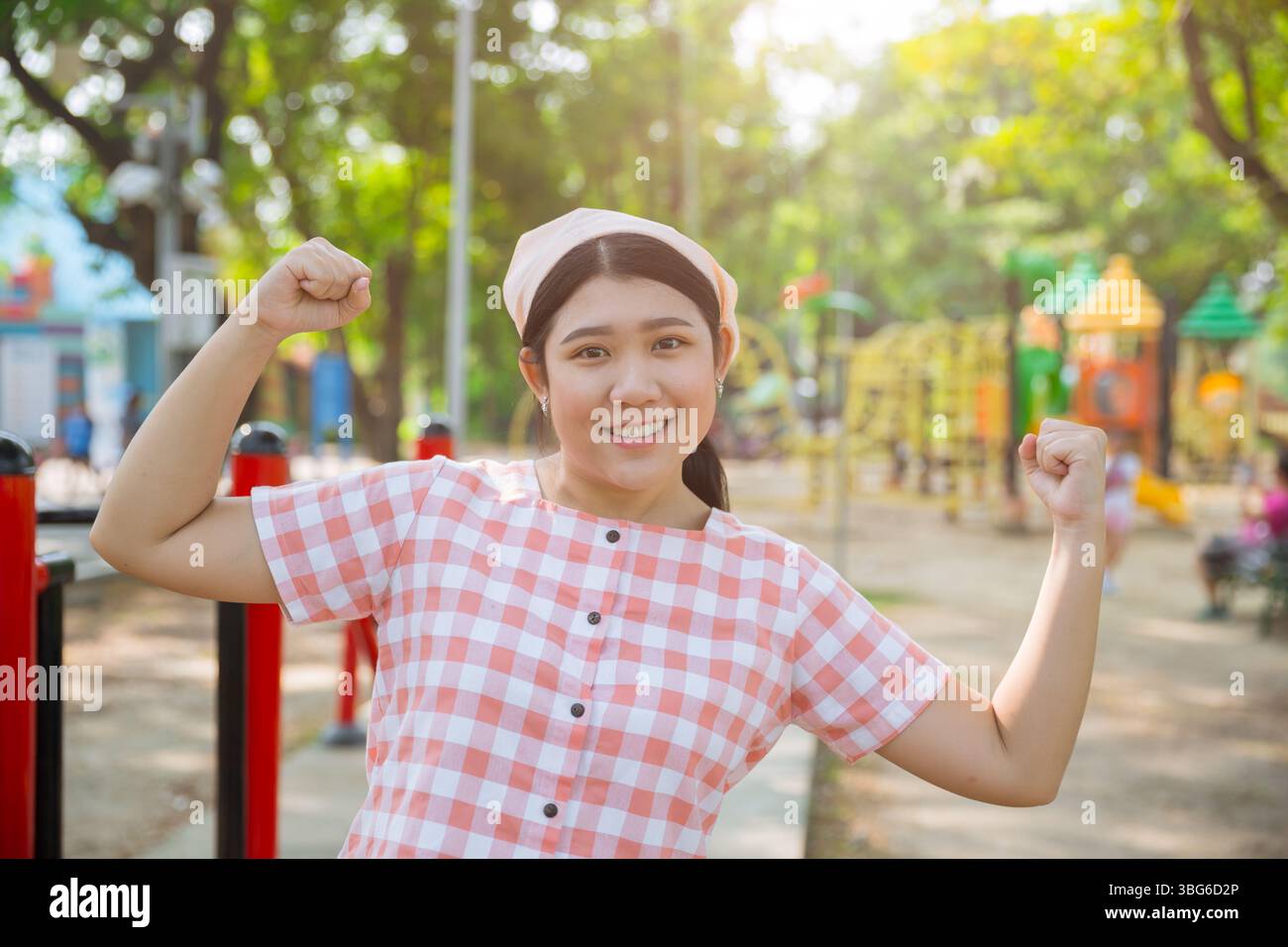 Bella giovane donna asiatica sana e grassa in piedi felice sorridente al parco verde di ricreazione sportiva all'aperto Foto Stock