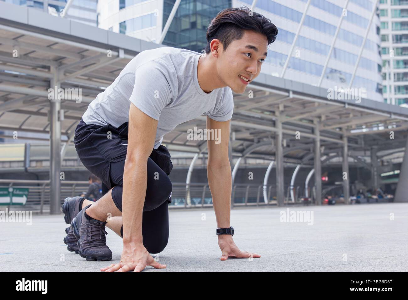 Sport sano asiatico cinese giovane uomo prepararsi pronto per andare a correre in città all'aperto uffici edificio background Foto Stock