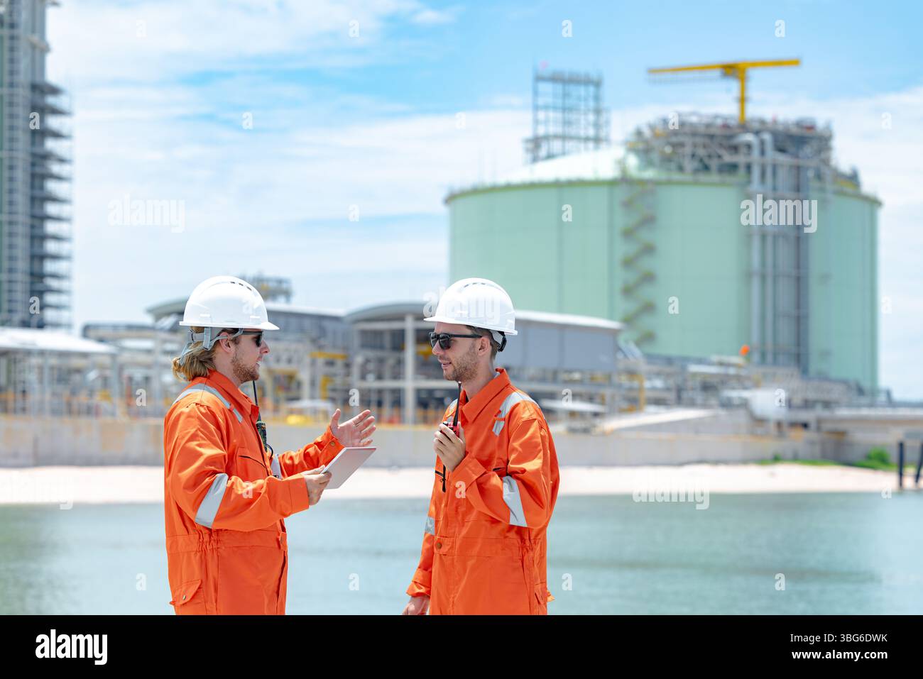 Lavoratori professionisti del settore petrolifero, ispezione di manutenzione di serbatoi di GNL di contenimento, ispettore del sito di gas onshore lavoro di squadra di sicurezza, IND petrolchimico nel settore petrolio e gas Foto Stock