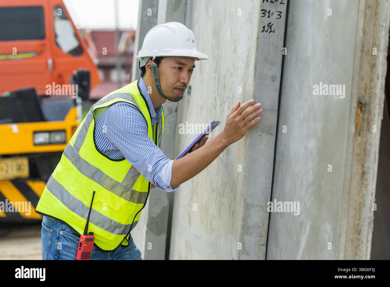 Ingegnere edile asiatico professionista, lavoratore edile giapponese lavoro maschile controllo di qualità delle pareti in calcestruzzo Foto Stock
