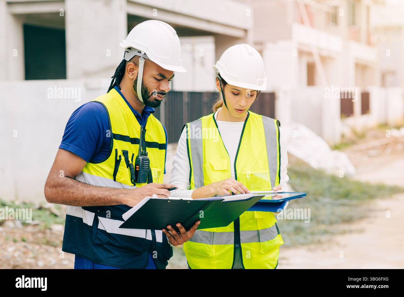 Team di ingegneri edili, ingegneri lavoro di squadra uomo e donne che lavorano insieme nel cantiere con progetti di costruzione a domicilio Foto Stock