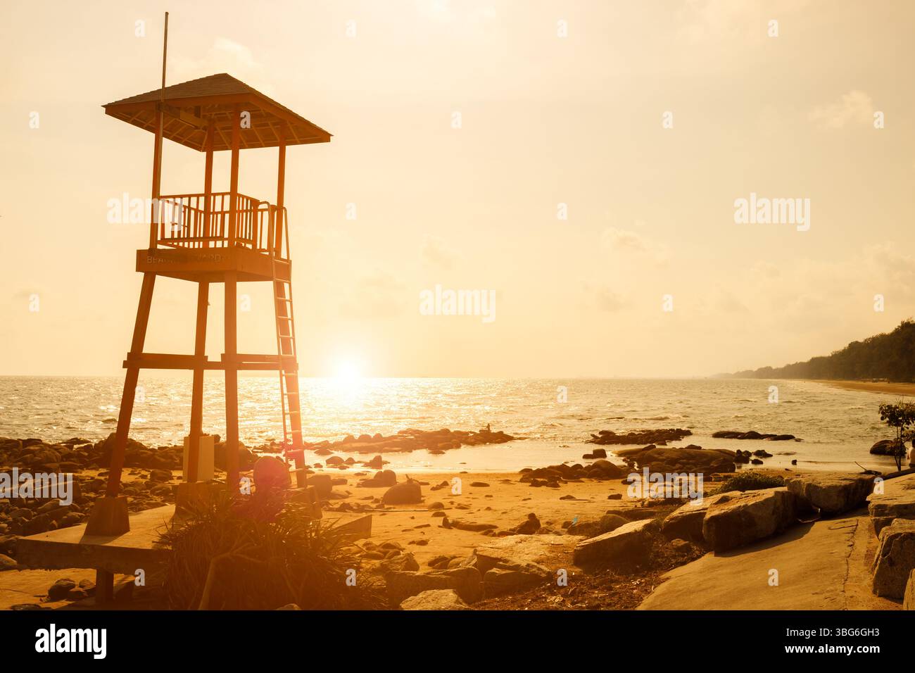 La Guardia di Spiaggia, la Guardia di salvataggio, guarda la torre che si trova sul mare pericoloso sullo sfondo del cielo del tramonto Foto Stock