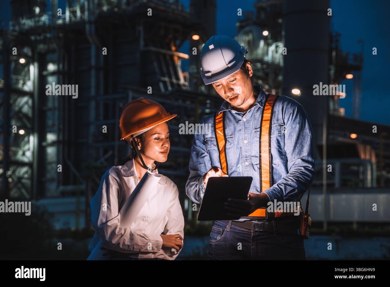 Team di ingegneri che lavorano di notte contro la centrale elettrica a turbina a gas di petrolio, ispettore di sorveglianza turno notturno all'aperto Foto Stock