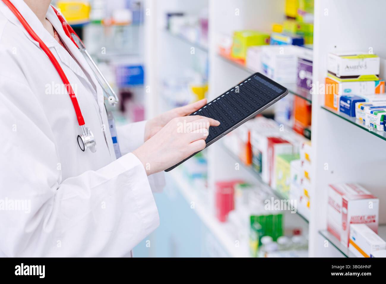Farmacista che lavora, medico tossicodipendente che utilizza un computer tablet per controllare i dettagli della durata di conservazione dei farmaci in magazzino con il database online dei dispositivi intelligenti Foto Stock