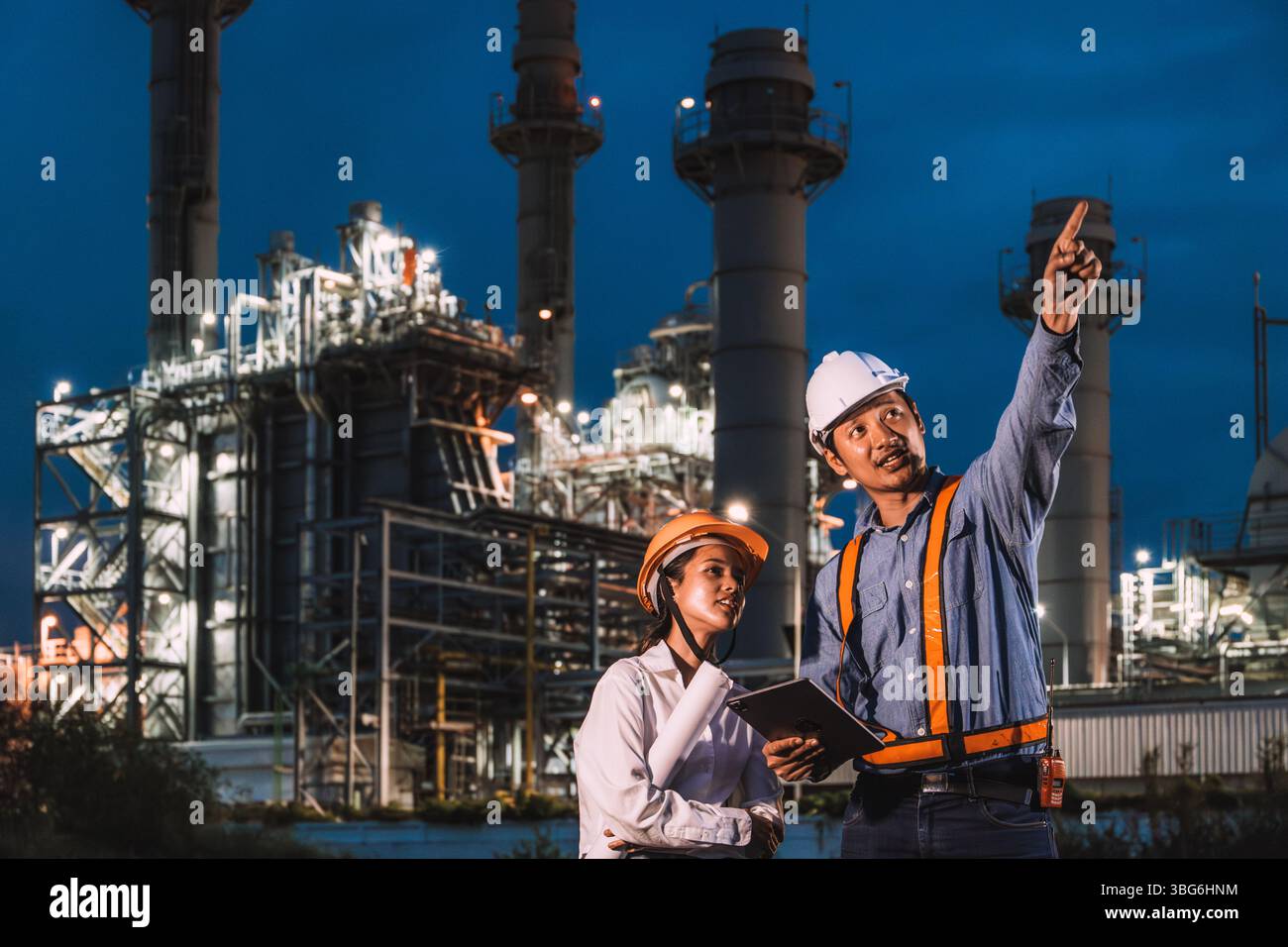 Team di ingegneri che lavorano di notte contro la centrale elettrica a turbina a gas di petrolio, ispettore di sorveglianza turno notturno all'aperto Foto Stock
