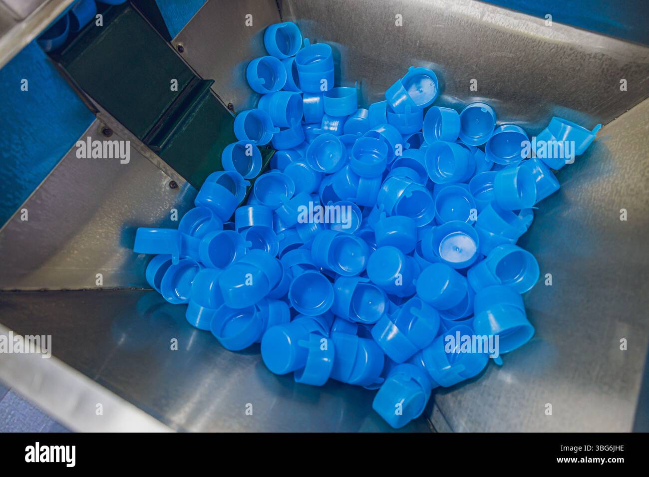 tappo in plastica nella macchina per il confezionamento di bevande in fabbrica Foto Stock