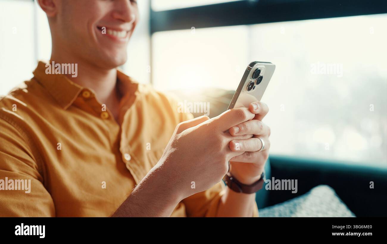 Giochi, videogiochi e uomo con smartphone, casa e intrattenimento per i gamer con tecnologia in salotto. Relax, giocatore e persona con app mobile per Foto Stock