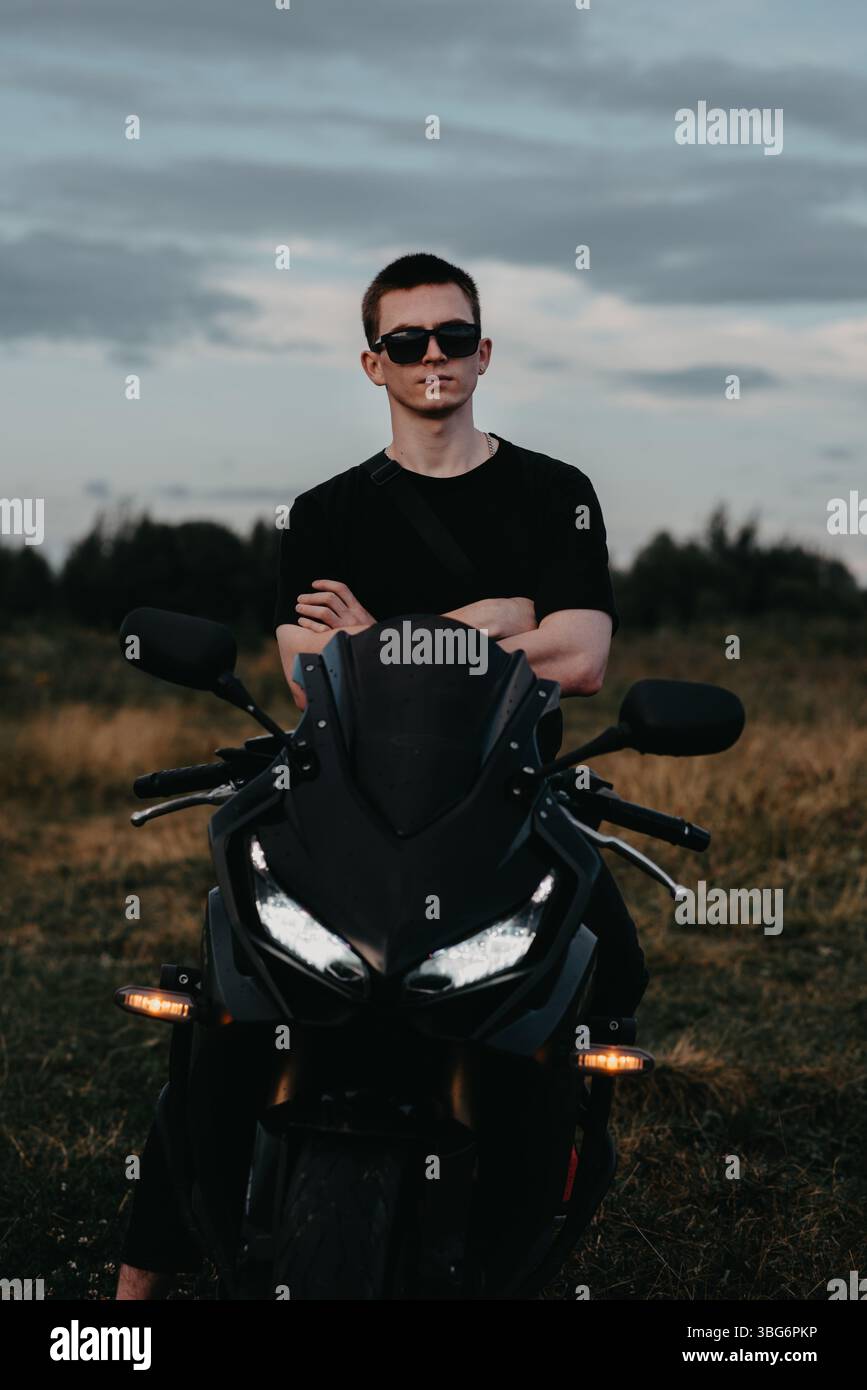 Ritratto di un motociclista maschio in un casco su una motocicletta sportiva Foto Stock