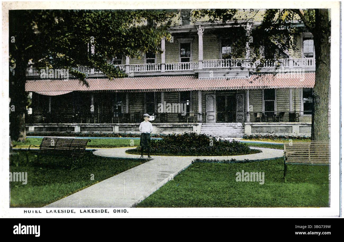 Questa fotografia a colori del 1921 raffigura il vecchio stile Hotel Lakeside a Lakeside, Ohio. Un ragazzo si erge sul passaggio pedonale di fronte all'hotel, mostrando il design dell'edificio e il contesto storico. Foto Stock