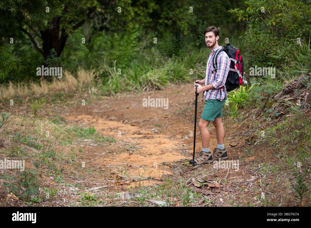 Escursionista maschile in piedi sul sentiero della foresta utilizzando un'asta da trekking e indossando zaino e stivali, spazio per copiare Foto Stock Escursionista maschile in piedi sul sentiero della foresta utilizzando un'asta da trekking e indossando zaino e stivali, spazio per copiare Foto Stock