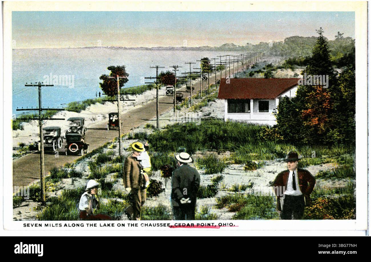 Questa vista mostra la strada che conduce al parco divertimenti Cedar Point lungo il lago. La scena cattura il paesaggio e l'avvicinamento al famoso parco. Foto Stock