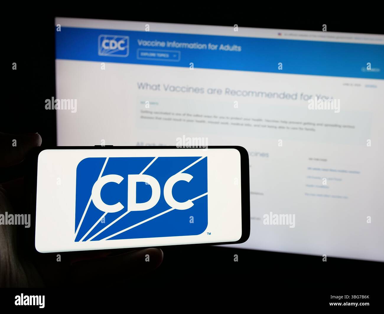Stoccarda, Germania - 01-28-2025: Persona in possesso di smartphone con il logo dei centri per il controllo e la prevenzione delle malattie (CDC) sullo schermo davanti al sito web Foto Stock
