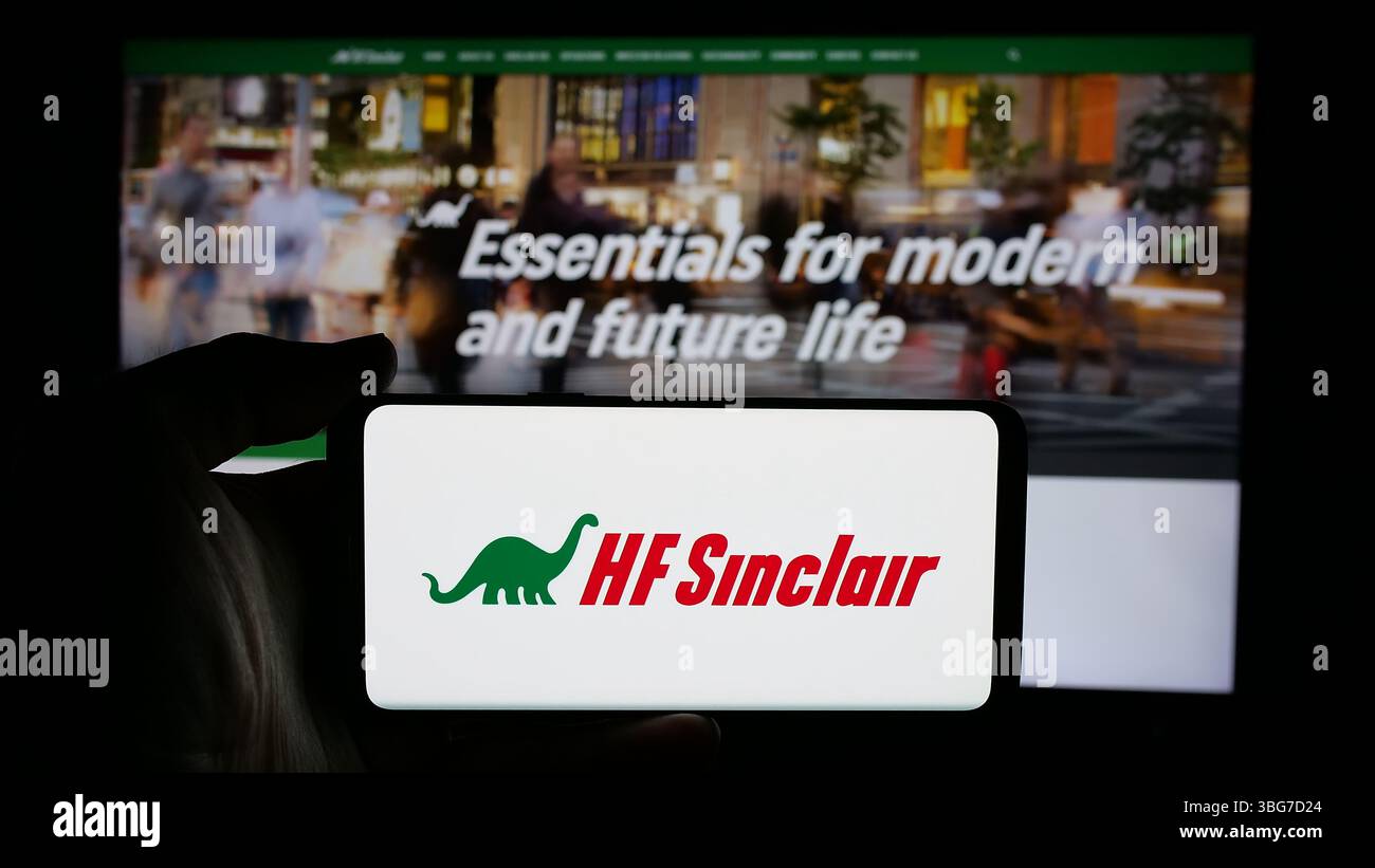 Stoccarda, Germania - 01-30-2025: Persona che detiene il cellulare con il logo della società energetica statunitense HF Sinclair Corporation sullo schermo Foto Stock