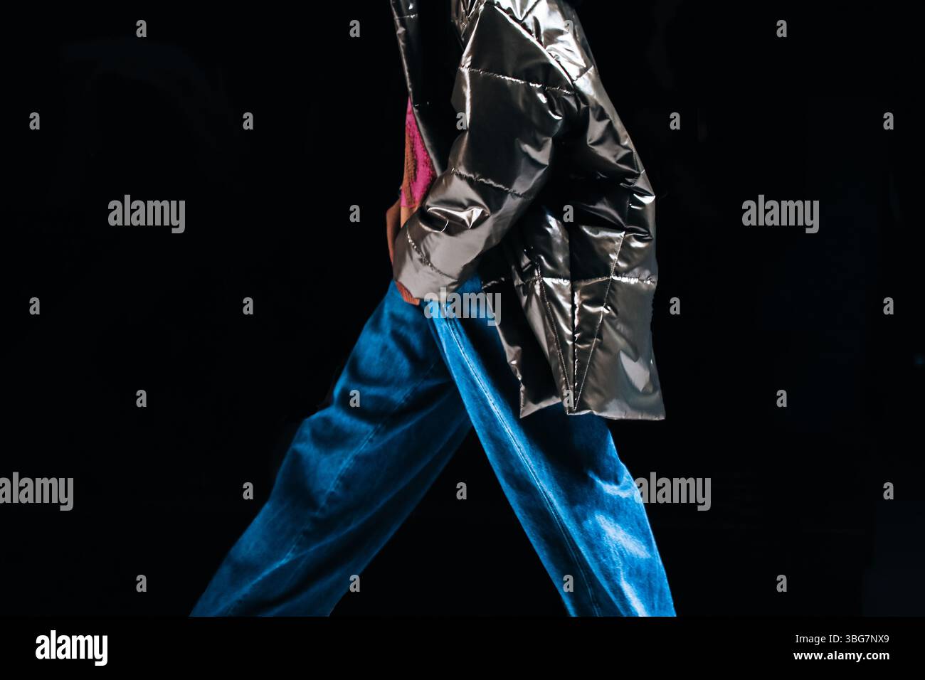 Donna che indossa un outfit elegante, jeans blu e giacca argento. Collezione di moda autunnale invernale Foto Stock