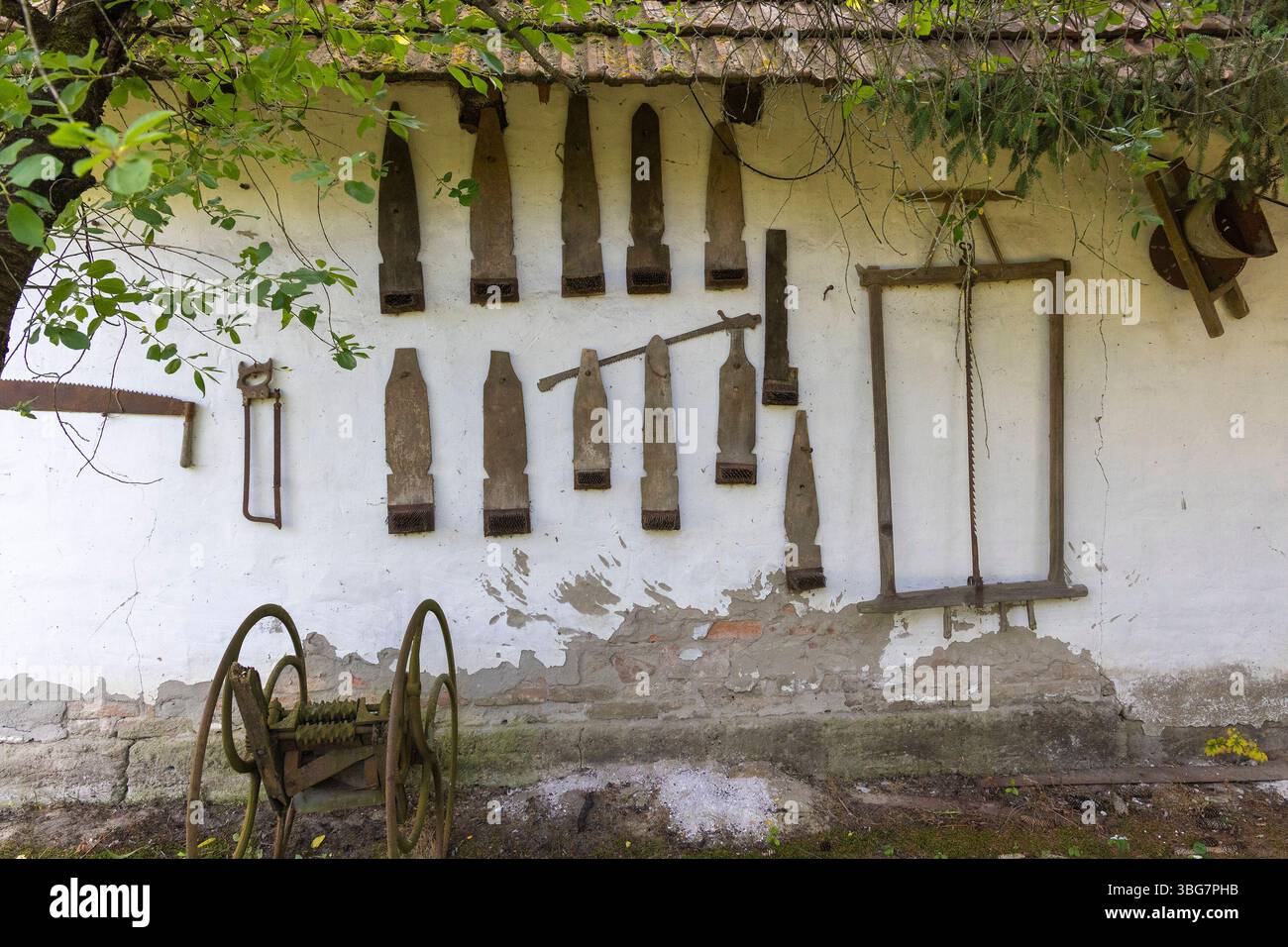 Utensili a mano d'epoca appesi su un muro in una tradizionale casa croata del villaggio Foto Stock