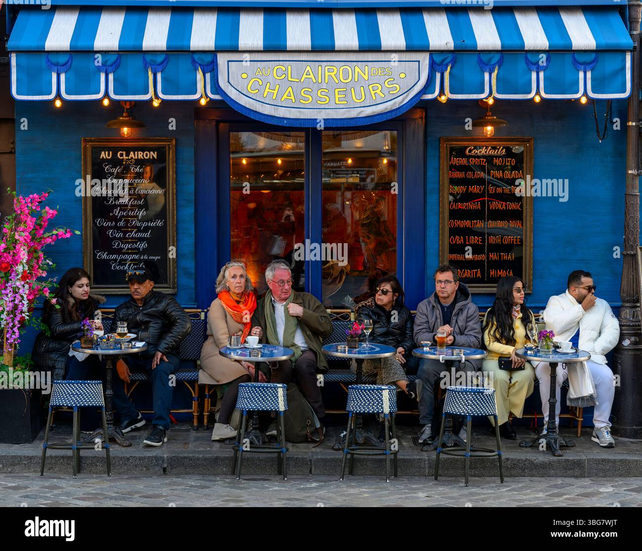 Persone che guardano in cima a Montmartre intorno a Place du Tertre. Con i turisti che bevono o mangiano all'aperto, godendosi la vita parigina. Foto Stock