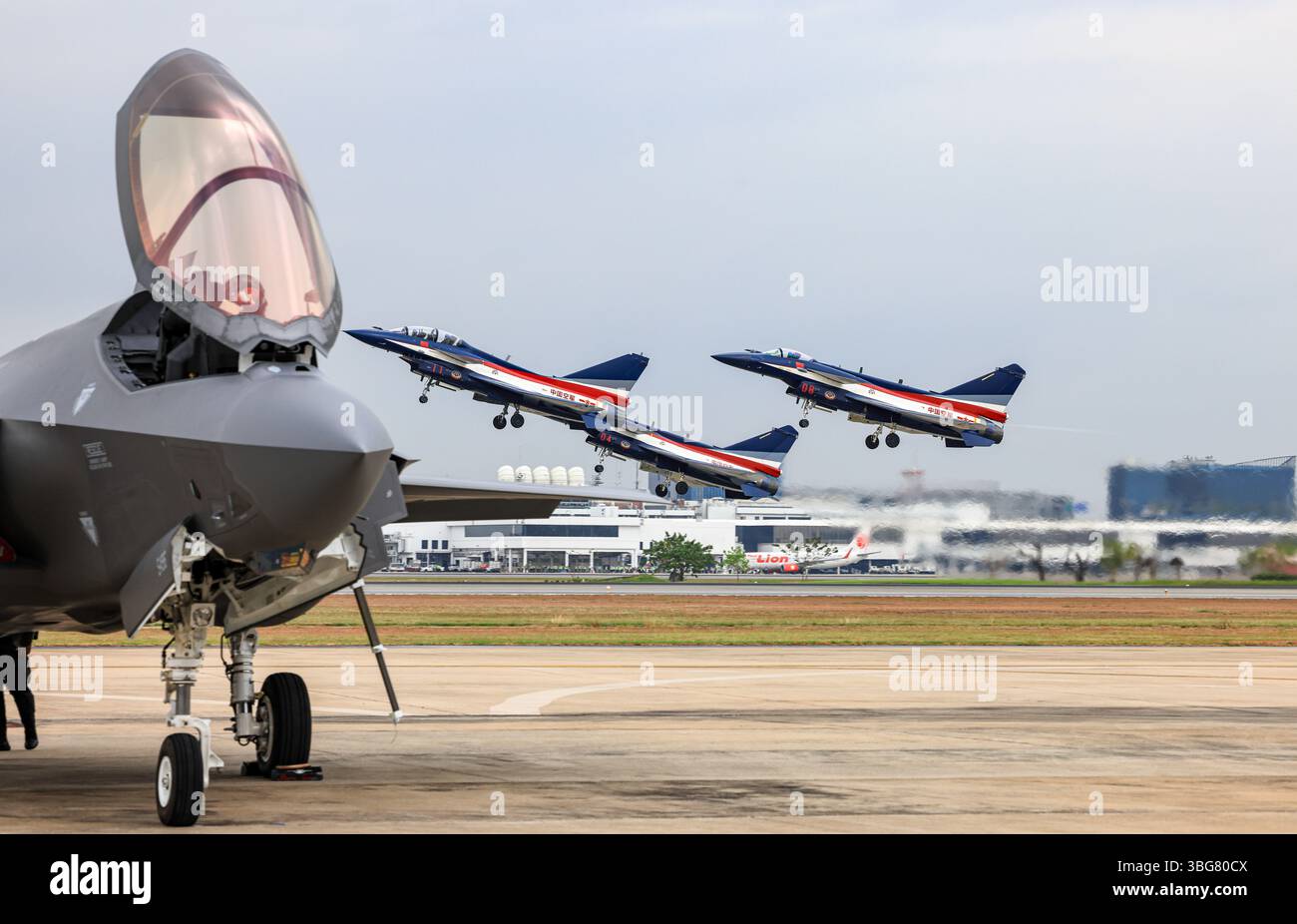 J-10 del team China Air Force Aerobatics su formazioni al decollo attraverso F-35 in occasione di un airshow in Thailandia. Foto Stock