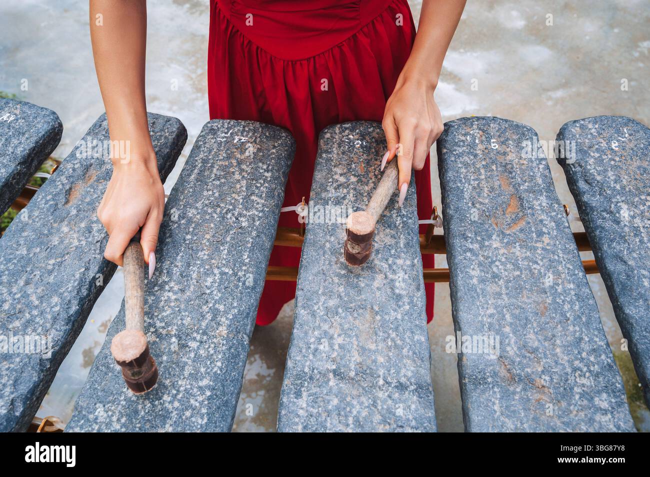 Primo piano delle mani di una donna che gioca su Dan da o litofono. Strumento musicale tradizionale vietnamita. Foto Stock