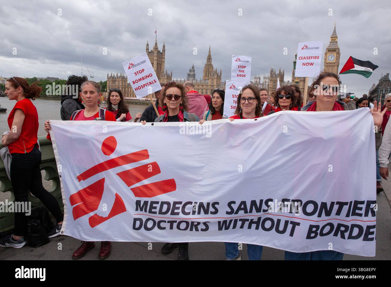 Londra, Regno Unito. 4 giugno 2025. Decine di migliaia di manifestanti che indossavano il rosso oggi circondarono il Parlamento, attraversando il ponte di Westminster e tornando sulla sponda opposta del Tamigi per fare un giro completo. Questi manifestanti hanno un banner per l'agenzia medica Medici senza frontiere, nota anche come Medici senza frontiere. Chiedono a Keir Starmer di tracciare una linea rossa e porre fine al genocidio di Gaza avviando un embargo sulle armi contro Israele. Crediti: Anna Watson/Alamy Live News Foto Stock