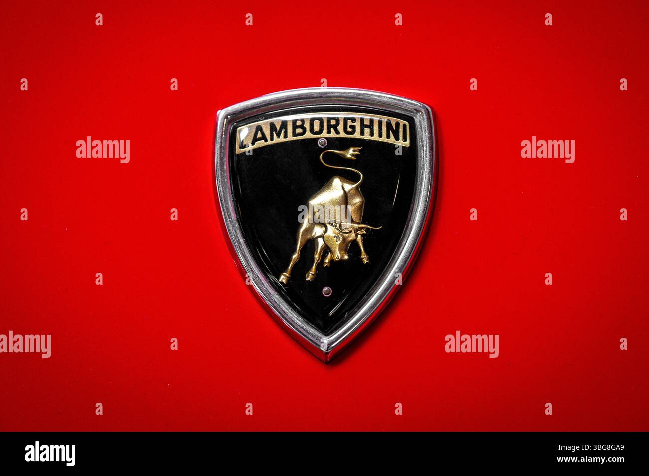 Somma Lombardo, Lombardia, Italia - 15 maggio 2025 : primo piano del logo Lamborghini dorato con stemma toro su un'auto d'epoca rossa Foto Stock