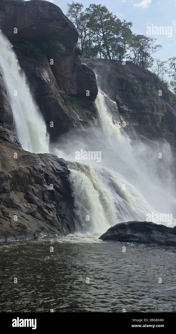 Le maestose cascate Athirappilly Falls in Kerala, India, si estendono attraverso le lussureggianti foreste verdi dei Ghati occidentali. Foto Stock