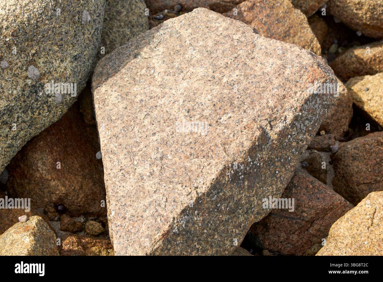 massi di granito locali disseminati sulla riva di fronte al faro di blacksod, contea di blacksod, mayo, repubblica d'irlanda Foto Stock