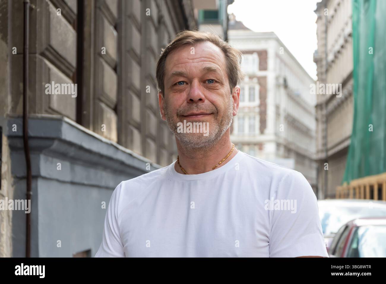 Primo piano del volto di un uomo di 50-55 anni con barba e baffi, colpito per strada. L'espressione del volto è calma e amichevole Foto Stock