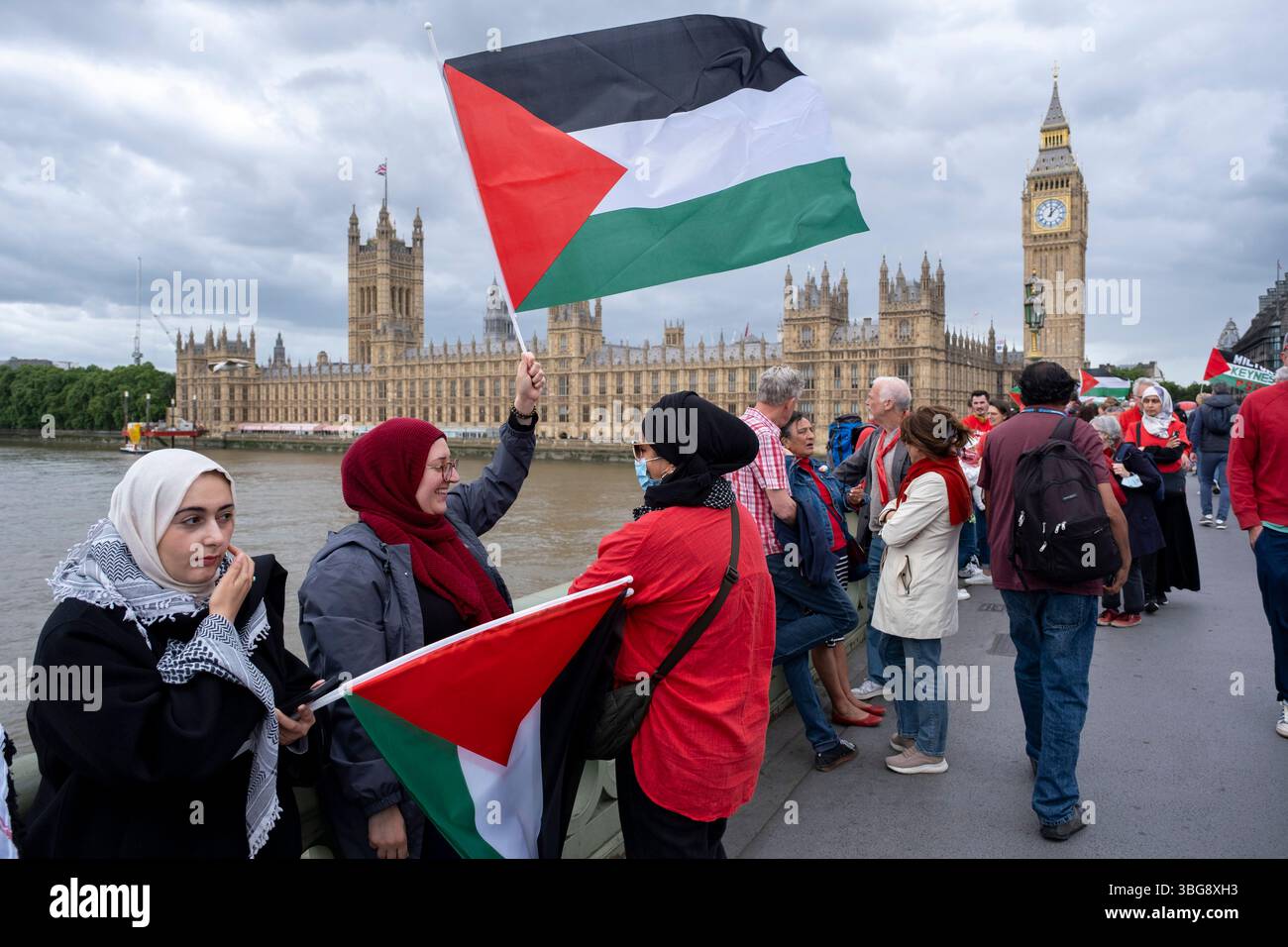 I manifestanti vestiti di rosso si riuniscono per una dimostrazione della linea Rossa per la Palestina che ha circondato il Parlamento organizzato dalla campagna di solidarietà per la Palestina il 4 giugno 2025 a Londra, Regno Unito. Si svolge durante le domande del primo Ministro con la richiesta di un embargo completo sulle armi e sanzioni contro Israele. Foto Stock