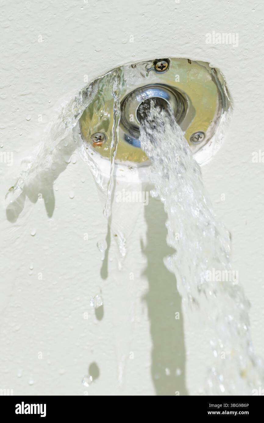 L'ingresso dell'acqua di una piscina di cemento armato è difettoso e l'acqua fuoriesce anche lateralmente Foto Stock