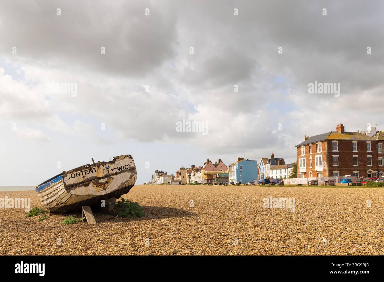 Aldeburgh, Suffolk. REGNO UNITO. Vista sulla spiaggia, con una barca da pesca abbandonata in primo piano. Foto Stock