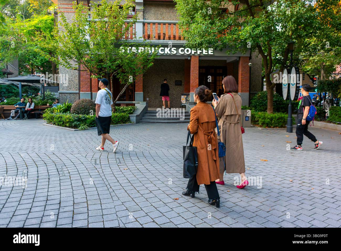 Shanghai, Cina, persone, donne, camminare, shopping, Starbucks Coffee Shop Front, Street Scene, area residenziale privata, quartiere residenziale Beizhan Foto Stock