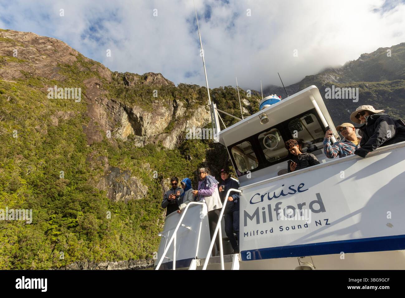 Turisti su una nave da crociera che passa attraverso il fiordo di Milford Sound, il parco nazionale di Fiordland, South Island, nuova Zelanda Foto Stock