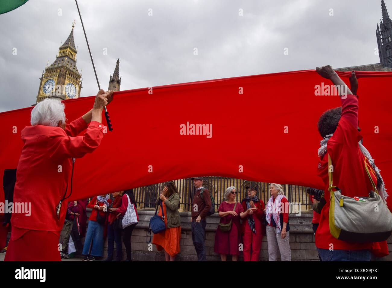 Londra, Regno Unito. 4 giugno 2025. I manifestanti pro-palestinesi si riuniscono fuori dalle camere del Parlamento chiedendo un embargo sulle armi contro Israele, che Israele interrompa i suoi attacchi a Gaza e che gli aiuti vengono erogati alla popolazione affamata. Centinaia di manifestanti tenevano un lungo tessuto rosso intorno al parlamento, simboleggiando le "linee rosse” attraversate da Israele. Crediti: Vuk Valcic/Alamy Live News Foto Stock