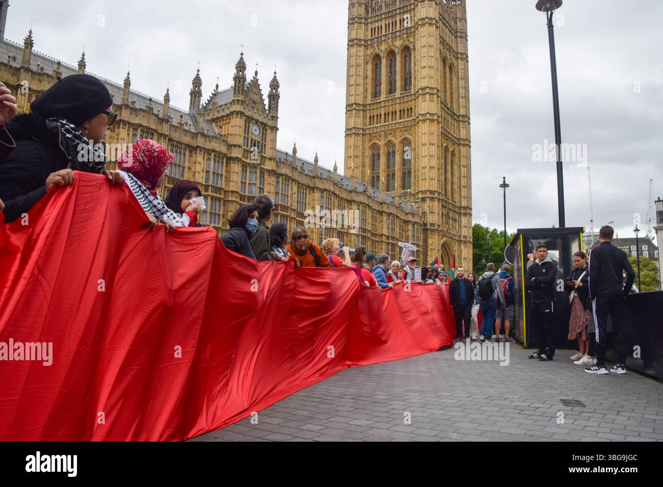 Londra, Regno Unito. 4 giugno 2025. I manifestanti pro-palestinesi si riuniscono fuori dalle camere del Parlamento chiedendo un embargo sulle armi contro Israele, che Israele interrompa i suoi attacchi a Gaza e che gli aiuti vengono erogati alla popolazione affamata. Centinaia di manifestanti tenevano un lungo tessuto rosso intorno al parlamento, simboleggiando le "linee rosse” attraversate da Israele. Crediti: Vuk Valcic/Alamy Live News Foto Stock