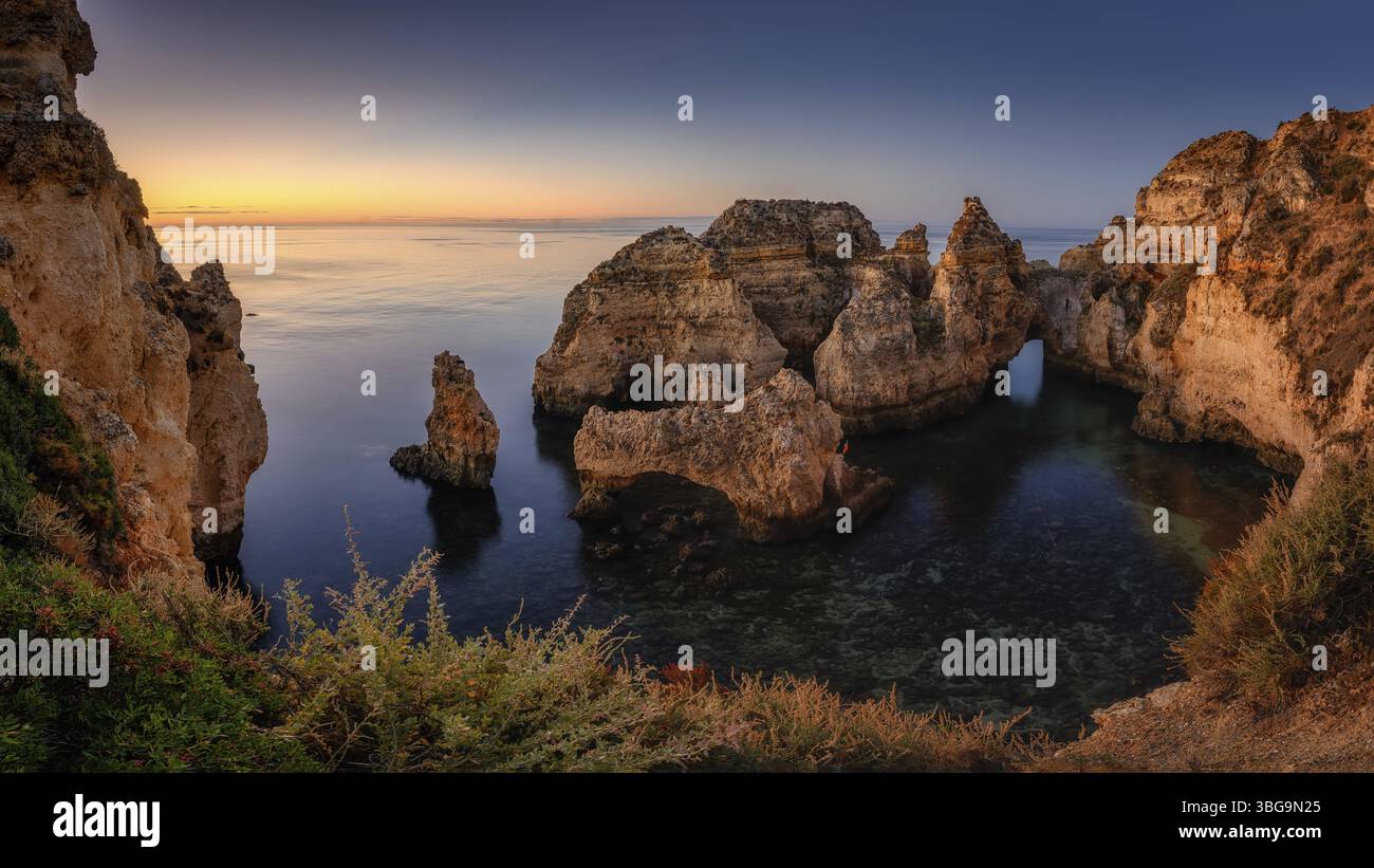 Lagos, Miradouro da Ponta da Piedade al tramonto, costa portoghese con un faro ai raggi del sole che tramonta Foto Stock