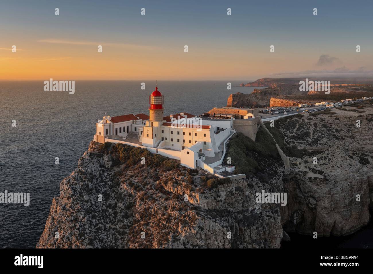 Costa portoghese con un faro tra i raggi del sole che tramonta, Cabo De Sao vincente al tramonto Foto Stock